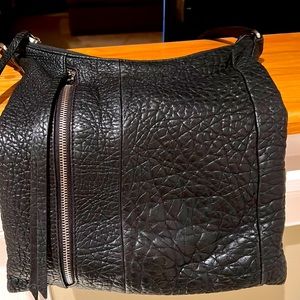 Black texture leather bag w adjustable strap & outside zip side pocket.